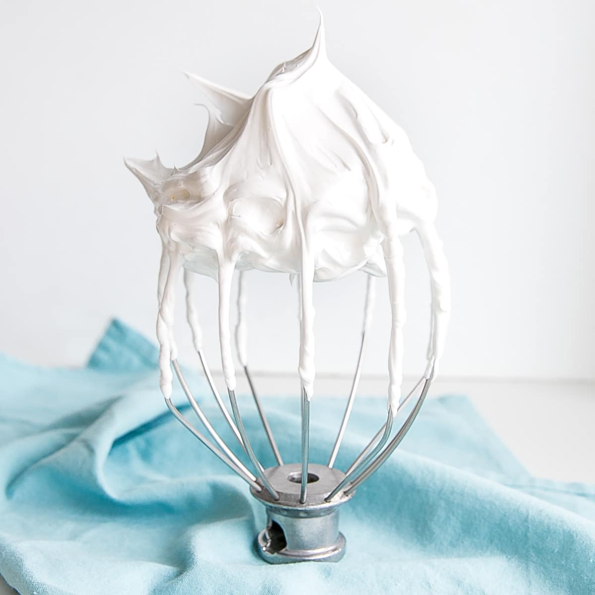 7 minute frosting shown on a stand mixer whisk.